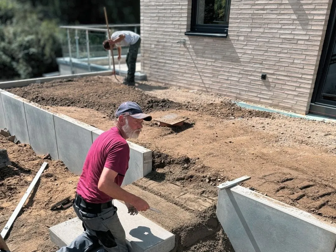 Mitarbeiter setzt Blockstufen zwischen Winkelstützen an einem Neubau.