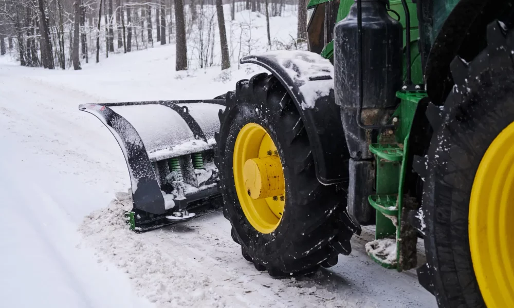 Big special tractor is removing snow from the forestal road.